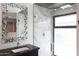 Modern bathroom featuring a glass-enclosed shower, marble countertops, and decorative framed mirrors at 1861 W Navarro Ave, Mesa, AZ 85202