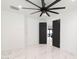 Minimal bedroom with black doors, a large fan, and sleek tile flooring, offers modern comfort at 1861 W Navarro Ave, Mesa, AZ 85202