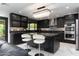 Modern kitchen featuring dark cabinetry, elegant countertops, and island seating under a stylish chandelier at 1861 W Navarro Ave, Mesa, AZ 85202