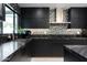 Stylish kitchen featuring black cabinets, granite countertops, stainless steel appliances, and a mosaic backsplash at 1861 W Navarro Ave, Mesa, AZ 85202