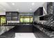 Sleek, modern kitchen featuring black cabinetry, granite countertops, and stainless steel appliances at 1861 W Navarro Ave, Mesa, AZ 85202