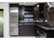 A modern kitchenette with stainless steel appliances, dark cabinetry, granite countertops, and marble flooring at 1861 W Navarro Ave, Mesa, AZ 85202