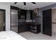 Bedroom features a kitchenette with black cabinetry, stainless steel appliances, and marble countertops at 1861 W Navarro Ave, Mesa, AZ 85202