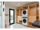 Bright laundry room featuring custom cabinets and a convenient stacked washer and dryer at 1861 W Navarro Ave, Mesa, AZ 85202