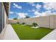 Spacious backyard with lush artificial turf, palm trees in a rock garden, and privacy walls at 20443 N 97Th Ave, Peoria, AZ 85382