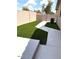 Low-maintenance backyard featuring synthetic grass and a concrete patio area for outdoor living at 20443 N 97Th Ave, Peoria, AZ 85382