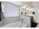 Modern bathroom showcasing a soaking tub with tile surround and a window with privacy blinds at 20443 N 97Th Ave, Peoria, AZ 85382