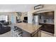 Open kitchen to living area shows the stainless refrigerator and large granite island with seating at 20443 N 97Th Ave, Peoria, AZ 85382