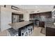 Bright kitchen with dark cabinets, granite countertops, stainless appliances, and a center island with seating at 20443 N 97Th Ave, Peoria, AZ 85382