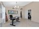 Neutral office with a dark office chair, tile floors, and a view into the kitchen at 20443 N 97Th Ave, Peoria, AZ 85382