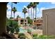 View of the community pool surrounded by lush landscaping and palm trees at 205 N 74Th St # 248, Mesa, AZ 85207