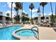 Inviting community pool and spa area surrounded by lounge chairs and palm trees at 205 N 74Th St # 248, Mesa, AZ 85207
