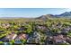 Aerial shot of the house and neighborhood featuring lush trees and mountain views at 20866 W Werner Pl, Buckeye, AZ 85396