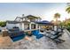 Resort-style backyard with luxurious pool, fire features, lounge chairs, and covered outdoor dining area at 20866 W Werner Pl, Buckeye, AZ 85396
