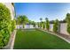 Well-manicured backyard with lush lawn, tasteful landscaping, and built-in trampoline at 20866 W Werner Pl, Buckeye, AZ 85396