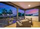Twilight view from a balcony with wicker furniture, palm trees, and landscape views at 20866 W Werner Pl, Buckeye, AZ 85396