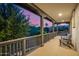An exterior balcony with a wooden railing and a view of the pink sky at dusk at 20866 W Werner Pl, Buckeye, AZ 85396