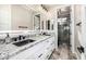 Bathroom featuring dual sinks with granite countertops, an illuminated mirror, and tile flooring at 20866 W Werner Pl, Buckeye, AZ 85396