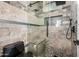 Shower with a glass door, gray tiling, a showerhead, and a small built in seat at 20866 W Werner Pl, Buckeye, AZ 85396