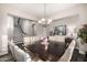 Spacious dining room with staircase view, featuring stylish chandelier and seating for eight at 20866 W Werner Pl, Buckeye, AZ 85396