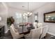 Well-lit dining room with dark wood table, decorative chandelier, and seating for six at 20866 W Werner Pl, Buckeye, AZ 85396