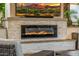 Elegant stone fireplace with a modern electric insert and a mounted TV for outdoor entertainment at 20866 W Werner Pl, Buckeye, AZ 85396