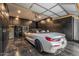 A luxury car is parked inside a spacious garage with custom cabinets and a glossy floor at 20866 W Werner Pl, Buckeye, AZ 85396