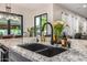 A kitchen island close-up view with a black sink and granite countertops at 20866 W Werner Pl, Buckeye, AZ 85396
