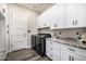 Bright laundry room with custom cabinets, granite countertops, and modern appliances at 20866 W Werner Pl, Buckeye, AZ 85396