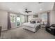 Spacious main bedroom with a tufted headboard, ceiling fan, and balcony access at 20866 W Werner Pl, Buckeye, AZ 85396
