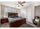 Bedroom featuring gray bedding and an ornamental, dark wood bed frame set on a gray carpet at 20866 W Werner Pl, Buckeye, AZ 85396