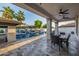Inviting outdoor patio featuring a dining area with views of the sparkling pool and mature trees at 20866 W Werner Pl, Buckeye, AZ 85396