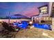 Backyard pool with fire bowls, poolside lounge chairs, and a purple umbrella table at 20866 W Werner Pl, Buckeye, AZ 85396