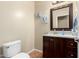 A charming half bathroom with a pedestal sink, dark wood cabinets, and decorative wall art at 21353 S 185Th Way, Queen Creek, AZ 85142