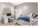 A teenager's bedroom features a desk and a cozy bed with a grey wall and lots of decor at 21353 S 185Th Way, Queen Creek, AZ 85142