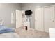 A modern bedroom boasts built-in closet storage, neutral carpet, and a contemporary mounted television at 21353 S 185Th Way, Queen Creek, AZ 85142