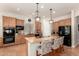 Well-equipped kitchen featuring granite countertops, wood cabinets, stainless steel appliances, and a large island at 21353 S 185Th Way, Queen Creek, AZ 85142