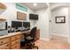 Well-lit home office with a built-in desk, dual monitors, and custom cabinetry, offering plenty of storage at 21353 S 185Th Way, Queen Creek, AZ 85142