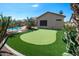 The backyard features a putting green, desert plants, and a pool surrounded by lush landscaping at 2270 E Indian Wells Dr, Chandler, AZ 85249