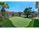 Enjoy the large backyard with putting green surrounded by trees and desert plants at 2270 E Indian Wells Dr, Chandler, AZ 85249
