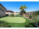 Lush backyard with putting green surrounded by mature landscaping and desert plants at 2270 E Indian Wells Dr, Chandler, AZ 85249