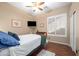 This well-lit bedroom offers dark-toned hardwood flooring, a ceiling fan, and plantation shutters at 2270 E Indian Wells Dr, Chandler, AZ 85249
