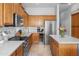 Well-lit kitchen featuring stainless steel appliances, ample counter space, and wooden cabinetry at 2270 E Indian Wells Dr, Chandler, AZ 85249