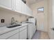 Laundry room features stylish cabinets, a sleek countertop, and modern washer and dryer units at 2270 E Indian Wells Dr, Chandler, AZ 85249