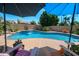 Backyard with a sparkling pool, rock waterfall feature, lush landscaping, and lounge chairs at 2270 E Indian Wells Dr, Chandler, AZ 85249