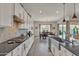Bright kitchen with black countertops, stainless appliances, and stylish backsplash open to dining at 22927 E Via Del Oro --, Queen Creek, AZ 85142