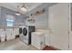 Charming laundry room with blue patterned wallpaper, modern appliances, and rustic-style shelves at 22927 E Via Del Oro --, Queen Creek, AZ 85142