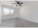 Bright bedroom features neutral tones, a ceiling fan, and a large window at 22963 W La Pasada Blvd, Buckeye, AZ 85326