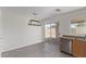 Open dining area featuring modern lighting, tile floors, and access to the backyard patio at 22963 W La Pasada Blvd, Buckeye, AZ 85326