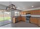 Bright kitchen with stainless steel appliances, wooden cabinets, and sliding door to the backyard at 22963 W La Pasada Blvd, Buckeye, AZ 85326